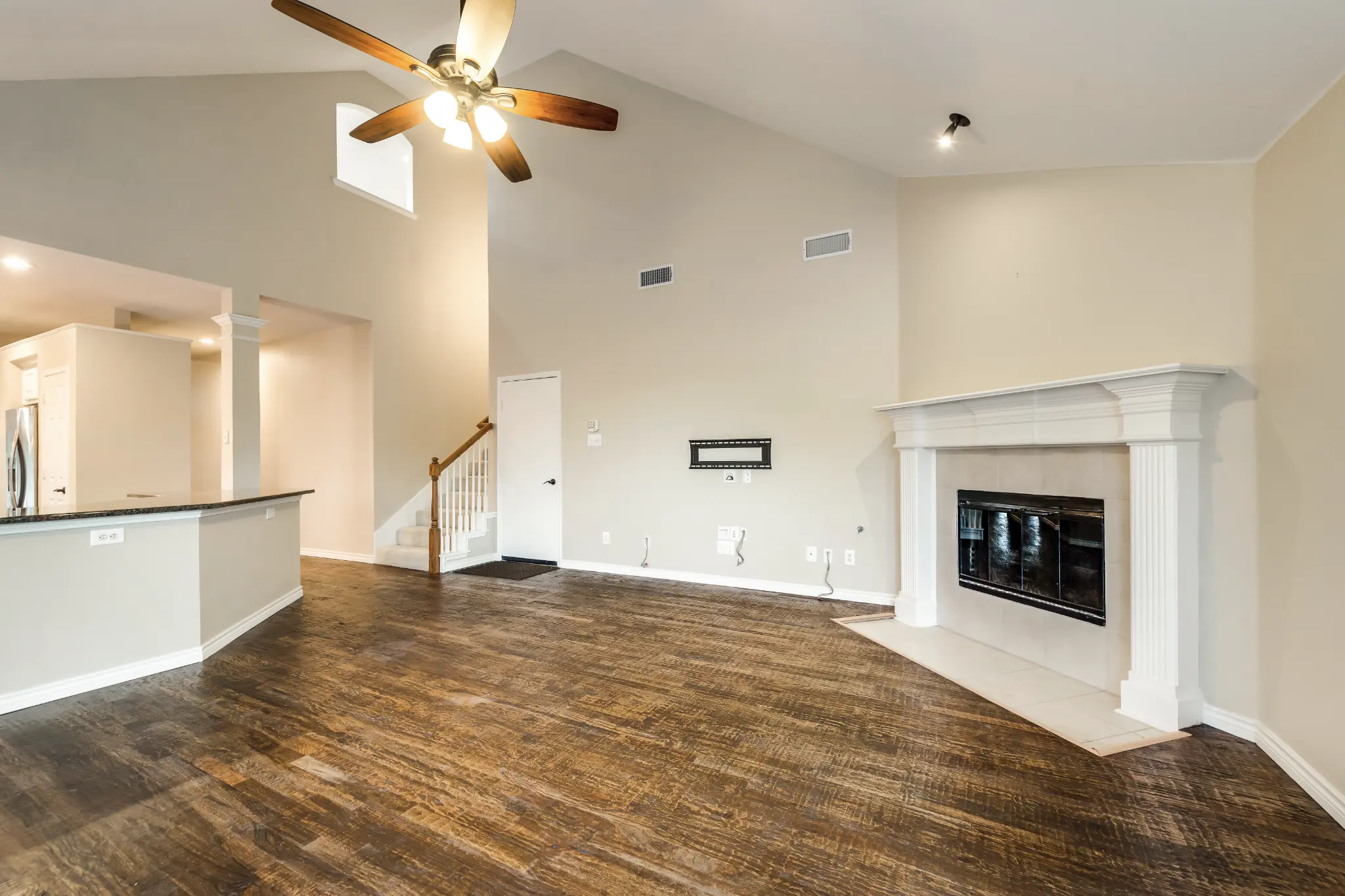 After: Open living room with fireplace and new hardwood floors – 10802 Tree Shadow Ln, Frisco TX