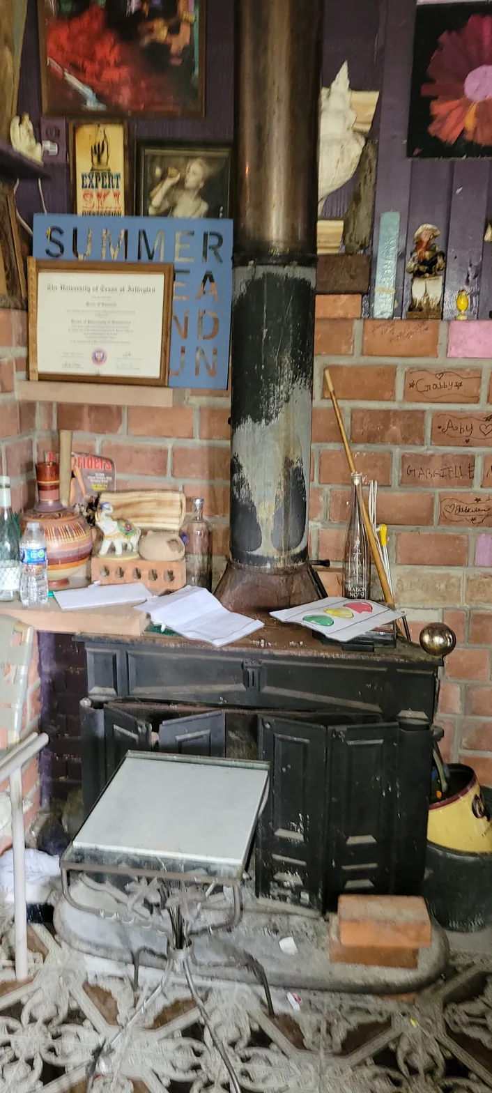 Interior of 2010 Wesley Dr Arlington TX showing wood burning stove and names written on exposed brick