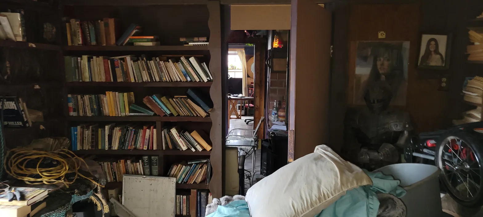 Cluttered interior room at 2010 Wesley Dr Arlington TX — floor-to-ceiling bookshelves and debris left behind