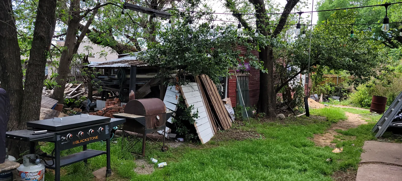 Backyard of 2010 Wesley Dr Arlington TX showing collapsed shed structure and squatter activity