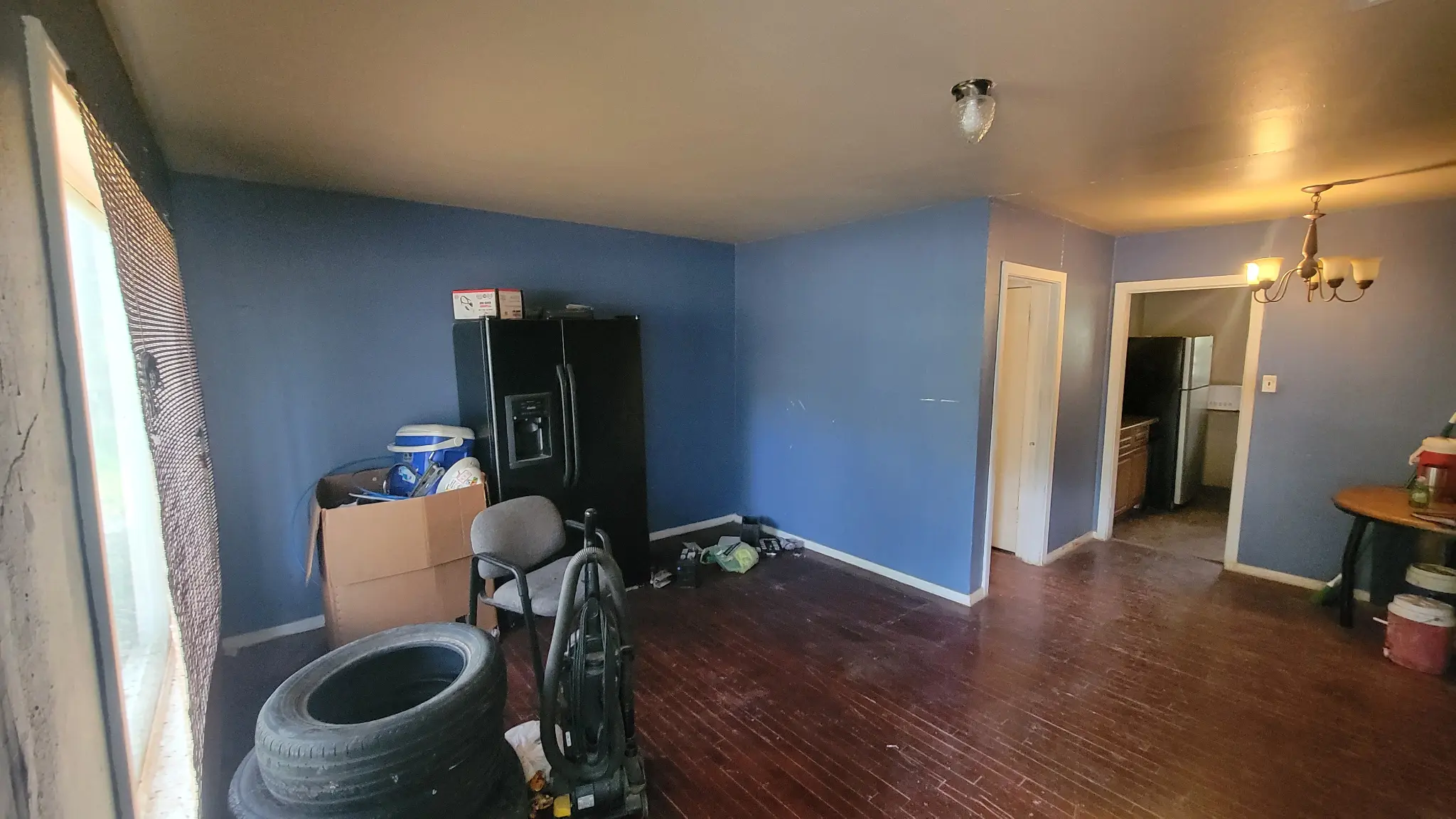 Benjamin Fort Worth property interior — living room with blue walls and belongings left behind