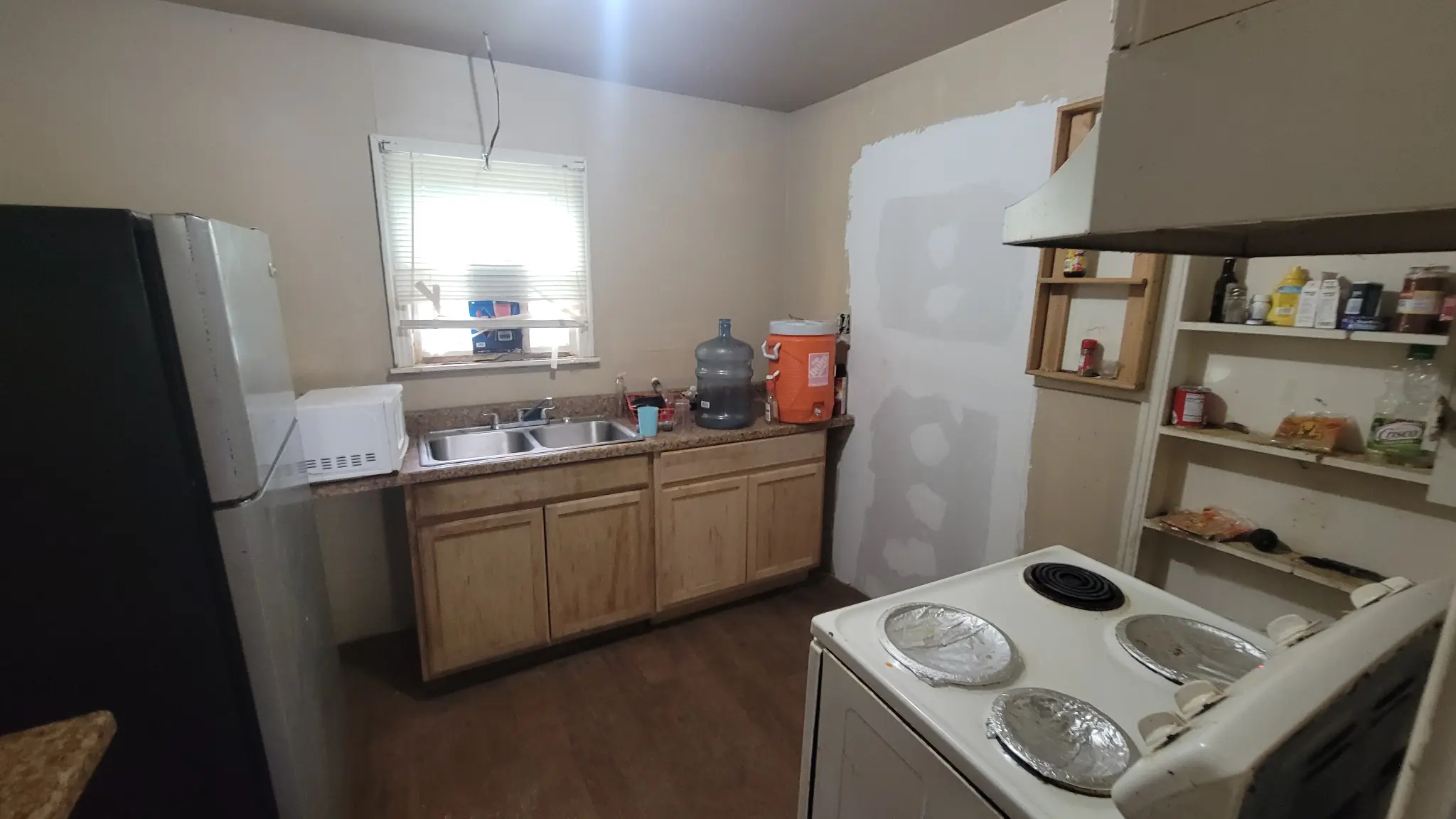 Benjamin Fort Worth property interior — kitchen with tan cabinets and white stove, as-is condition
