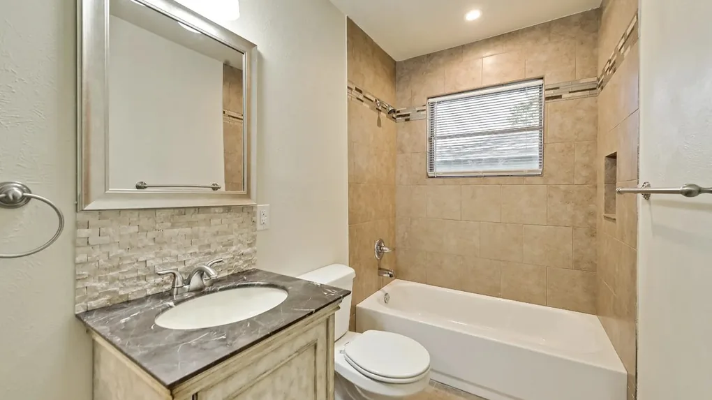 After: Fully renovated bathroom with new fixtures and tile