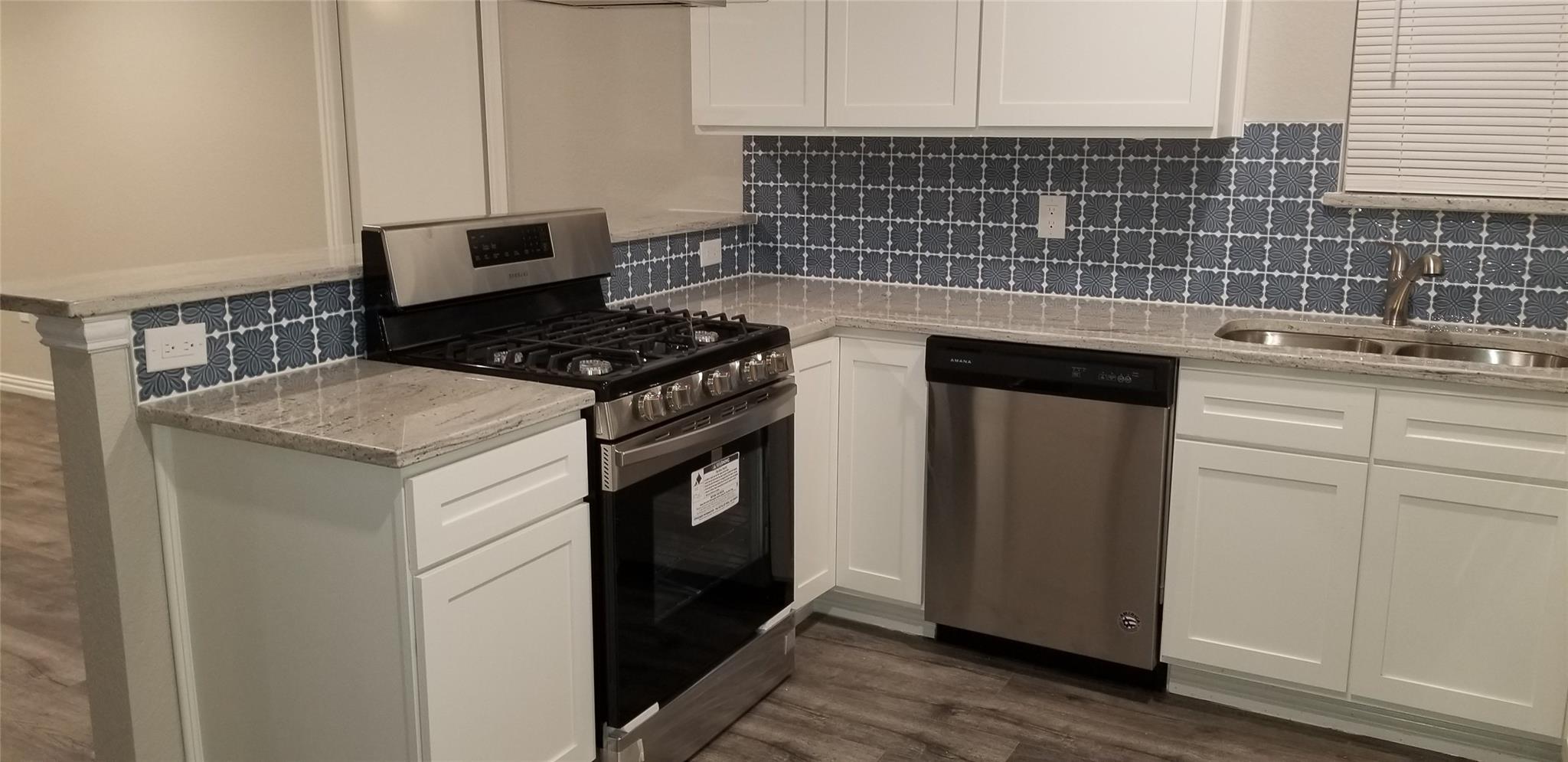 Garland TX house after remodel modern kitchen with granite counters and custom tile backsplash - DFW I Buy Houses